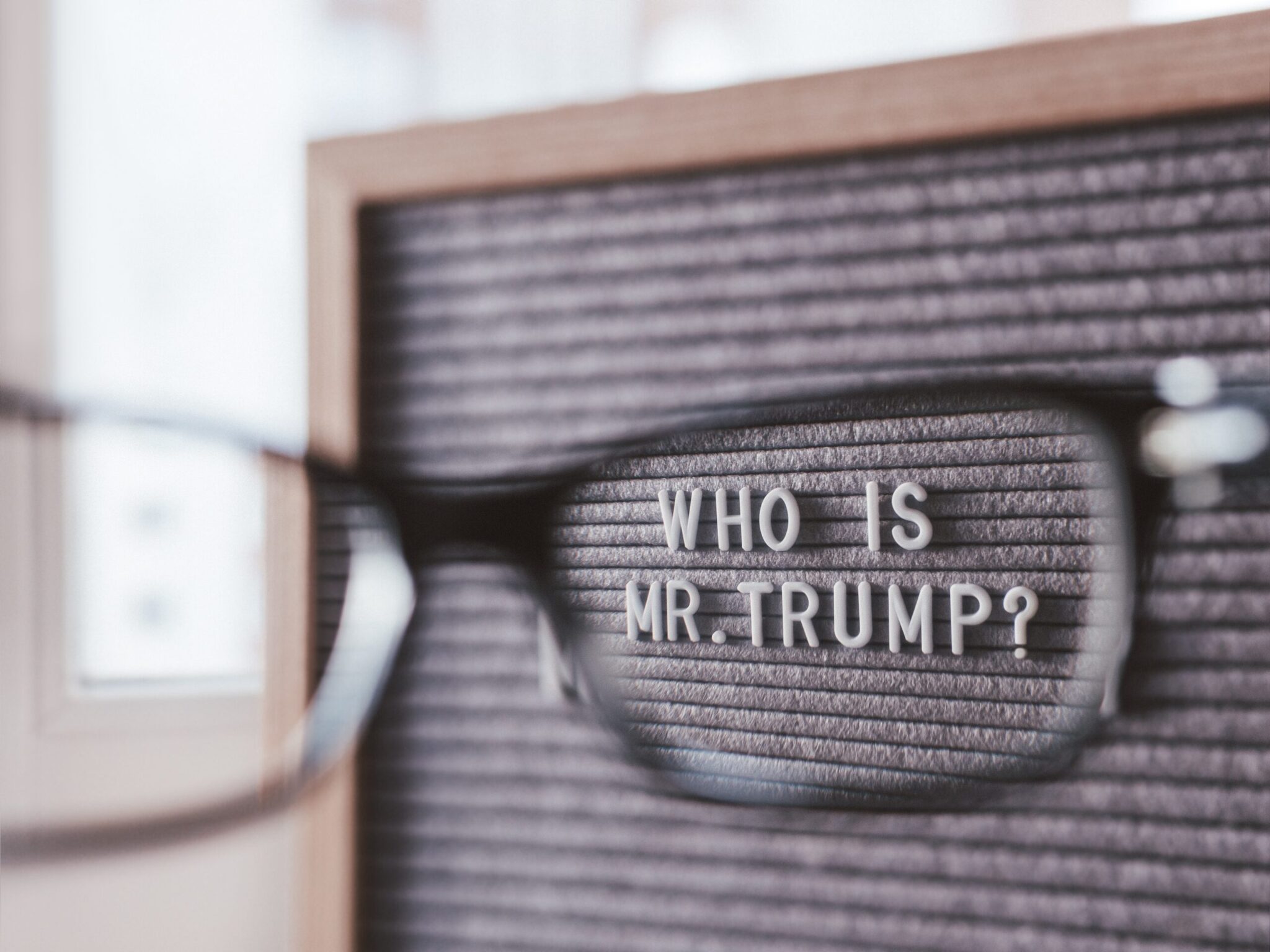 Letterboard with question WHO IS MR.TRUMP? through eyeglasses. C Letterboard with question WHO IS MR.TRUMP? through eyeglasses. C
