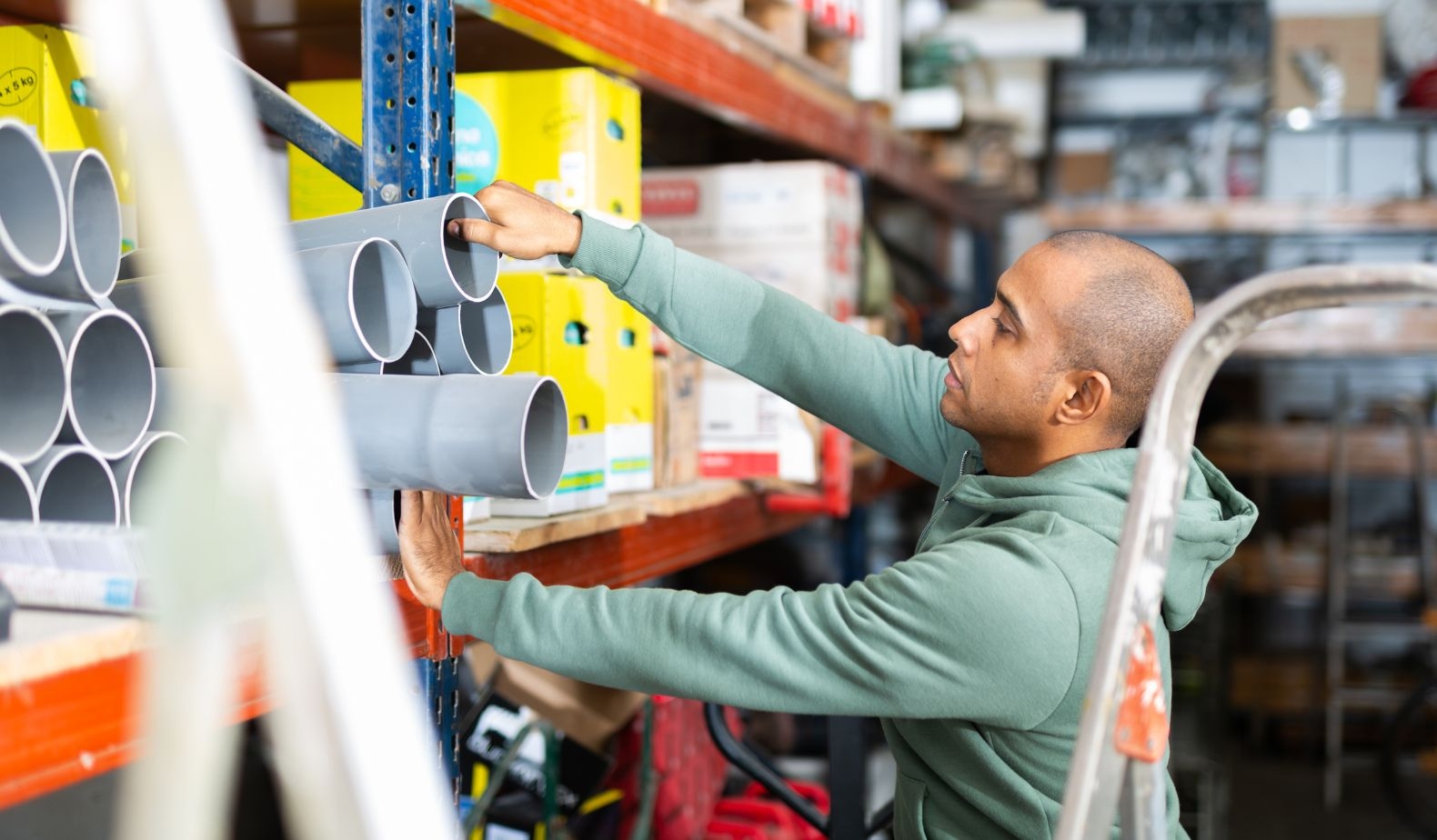 Male employee pulling building materials out of a shelf at construction ecommerce